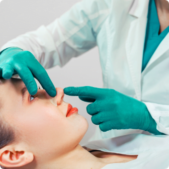 rhinoplasty-surgeon-hands-touches-patient-s-nose@2x